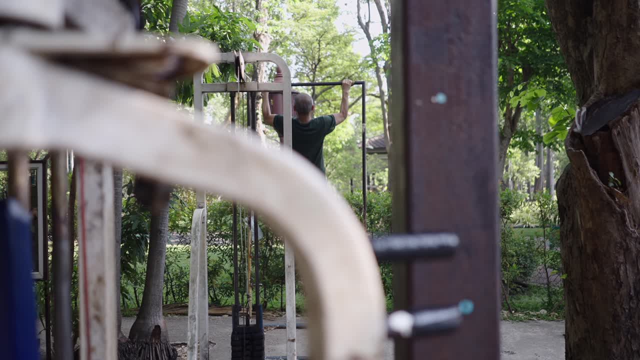 Man doing pull-ups on an outdoor exercise machine
