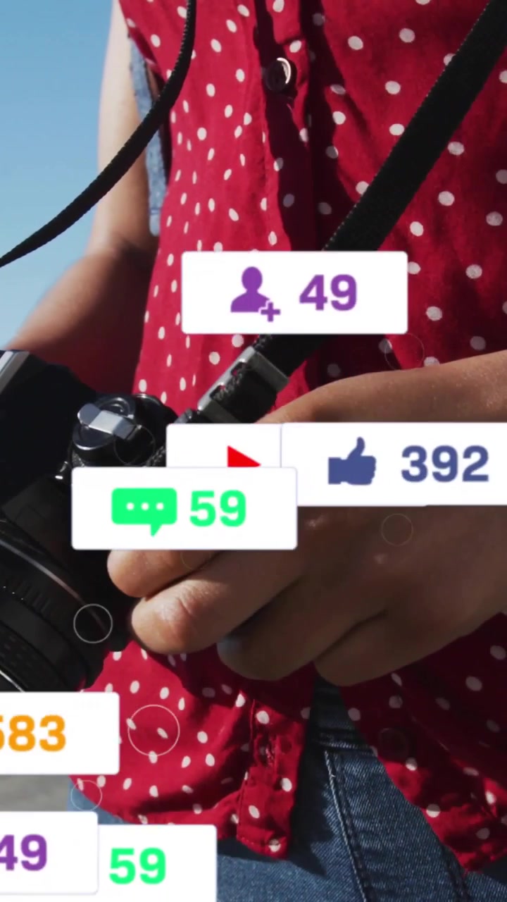 Female photographer after holding camera steady outdoors, badges popping over lens showing growth