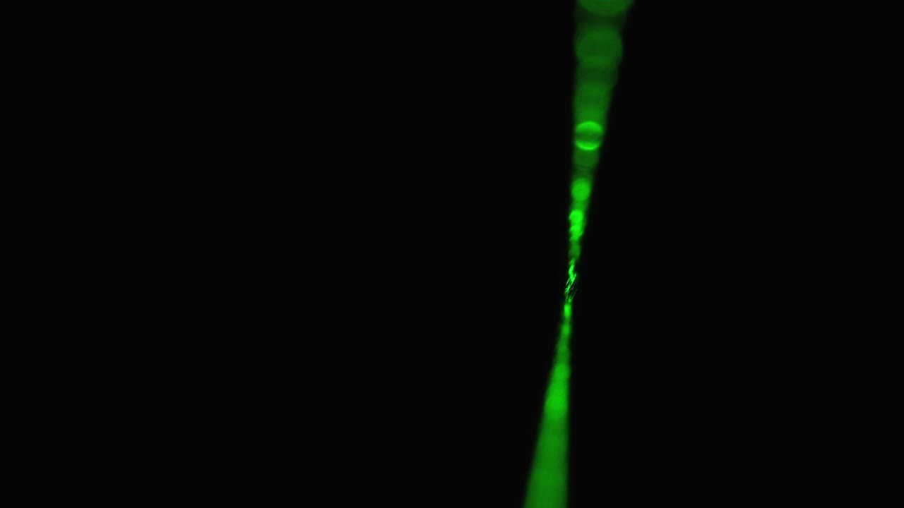 rayo láser verde sobre un fondo negro. rayo láser de potencia que brilla en la niebla
