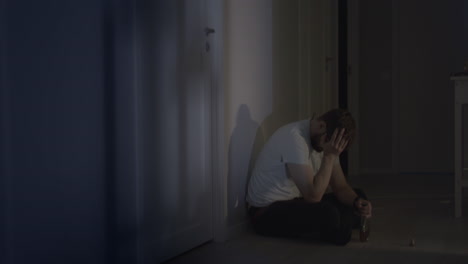 Male-man-sad-and-depressed-while-drinking-alcohol-at-home-hallway