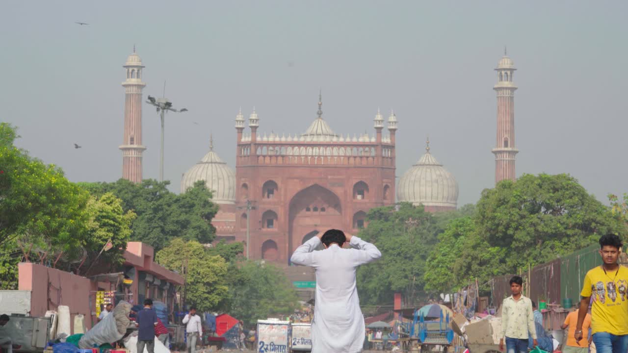 Indischer Mann geht vor der Jama Masjid in Delhi entlang.