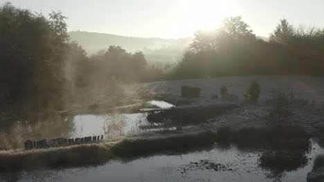 Wooden pier on small lake in rural countryside on foggy morning