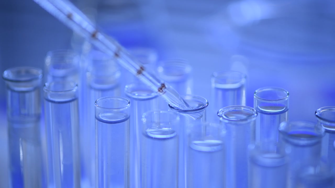 Pipetta da laboratorio che fa cadere liquido trasparente in una provetta