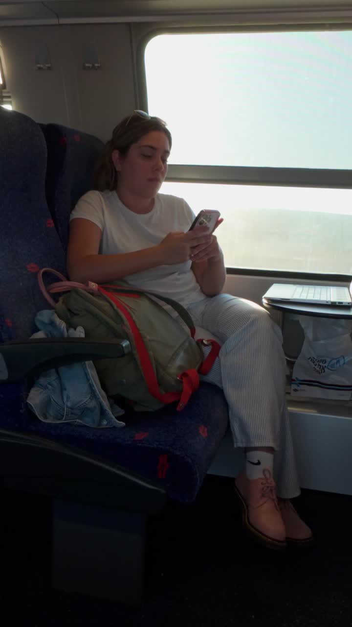Young Woman Reading on Her Phone While Traveling by Train