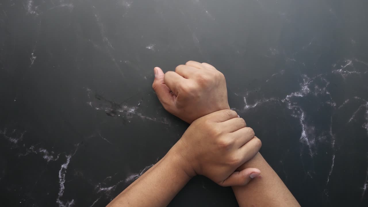 las manos juntas en las muñecas