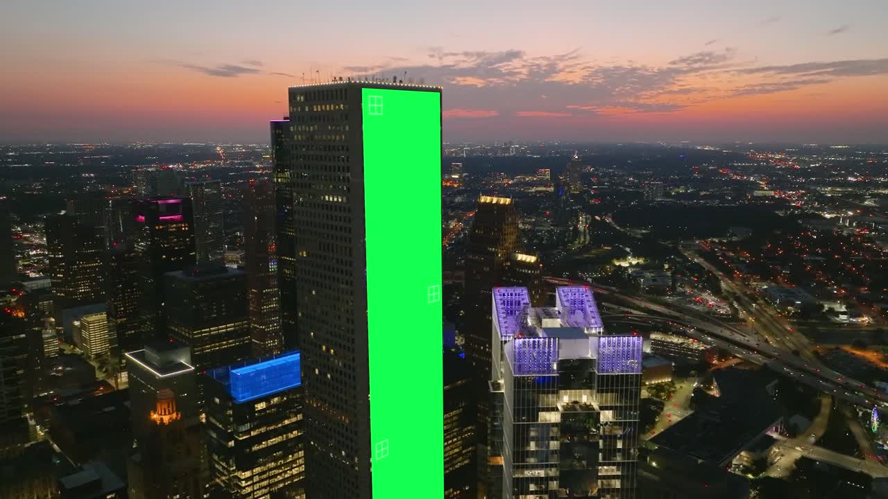 초록색 스크린 배너가 마천루 벽에 추적되어, 어두운 도시 배경 - vfx 시각