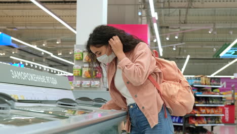 woman shopping for frozen food in a supermarket during pandemic