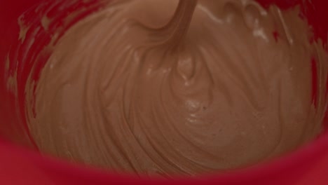 close-up view inside the bowl while whisking together ice cream and chocolate