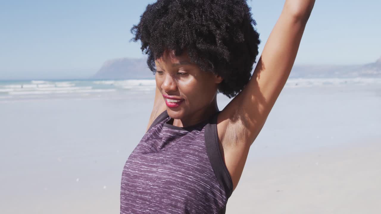 African American woman stretching out on the beach and blue sky background