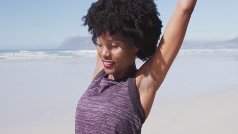 african american woman stretching out on the beach and blue sky background