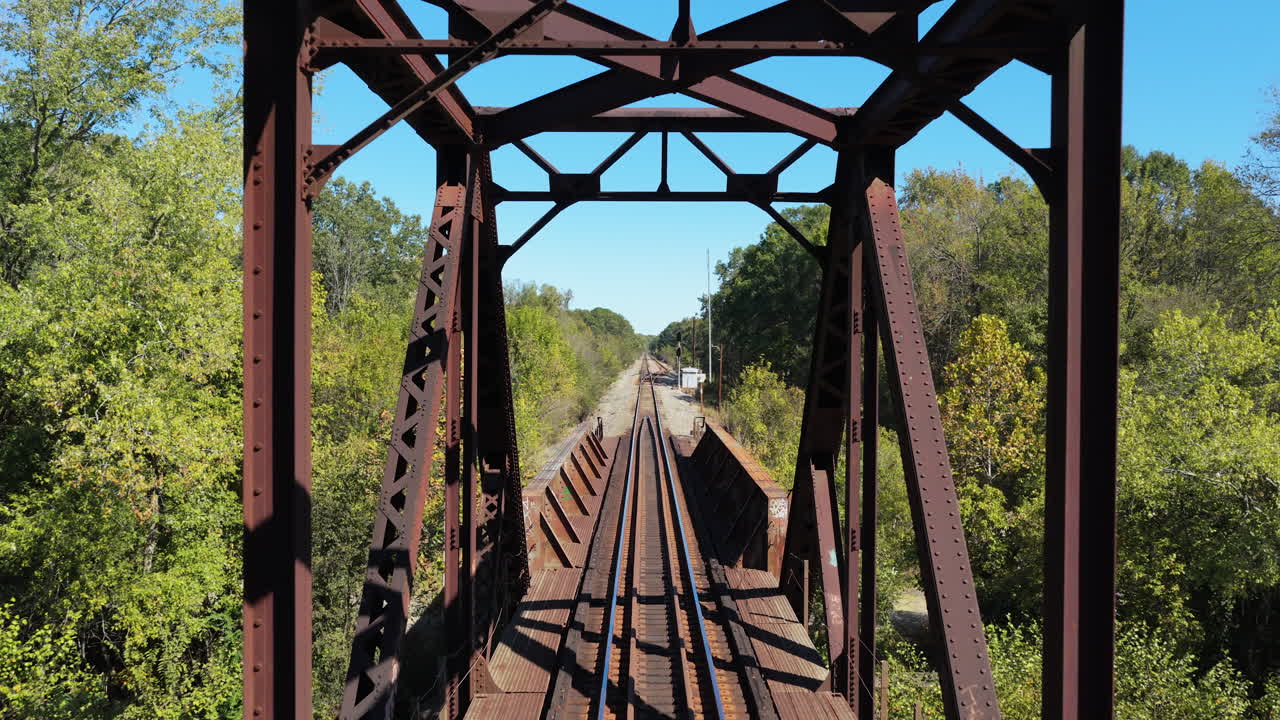 Vecchio ponte ferroviario in acciaio arrugginito con travature sul fiume Saline a Benton, Arkansas, Stati Uniti. Ripresa aerea in allontanamento.