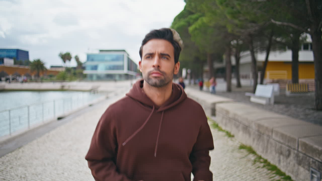 Closeup sportsman running street along riverside. Handsome man training outdoors