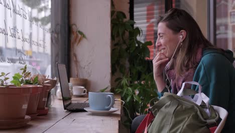 Young-woman-having-an-online-meeting-in-a-small-local-coffee-shop