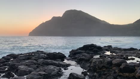 Amanecer-Temprano-En-La-Mañana-En-La-Playa-De-Makapuu-En-La-Isla-De-Oahu-Con-Surfistas-En-El-Fondo-Esperando-Una-Gran-Marea