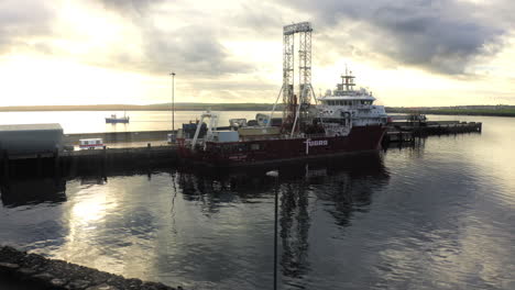 ferry fugro en el puerto con la puesta de sol en el fondo