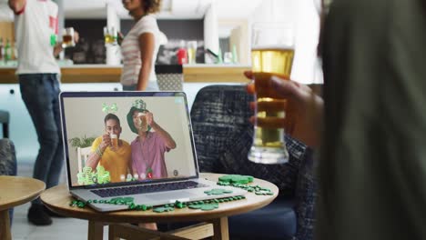 Woman having beer on laptop video call celebrating st patrick&#039;s day with friends