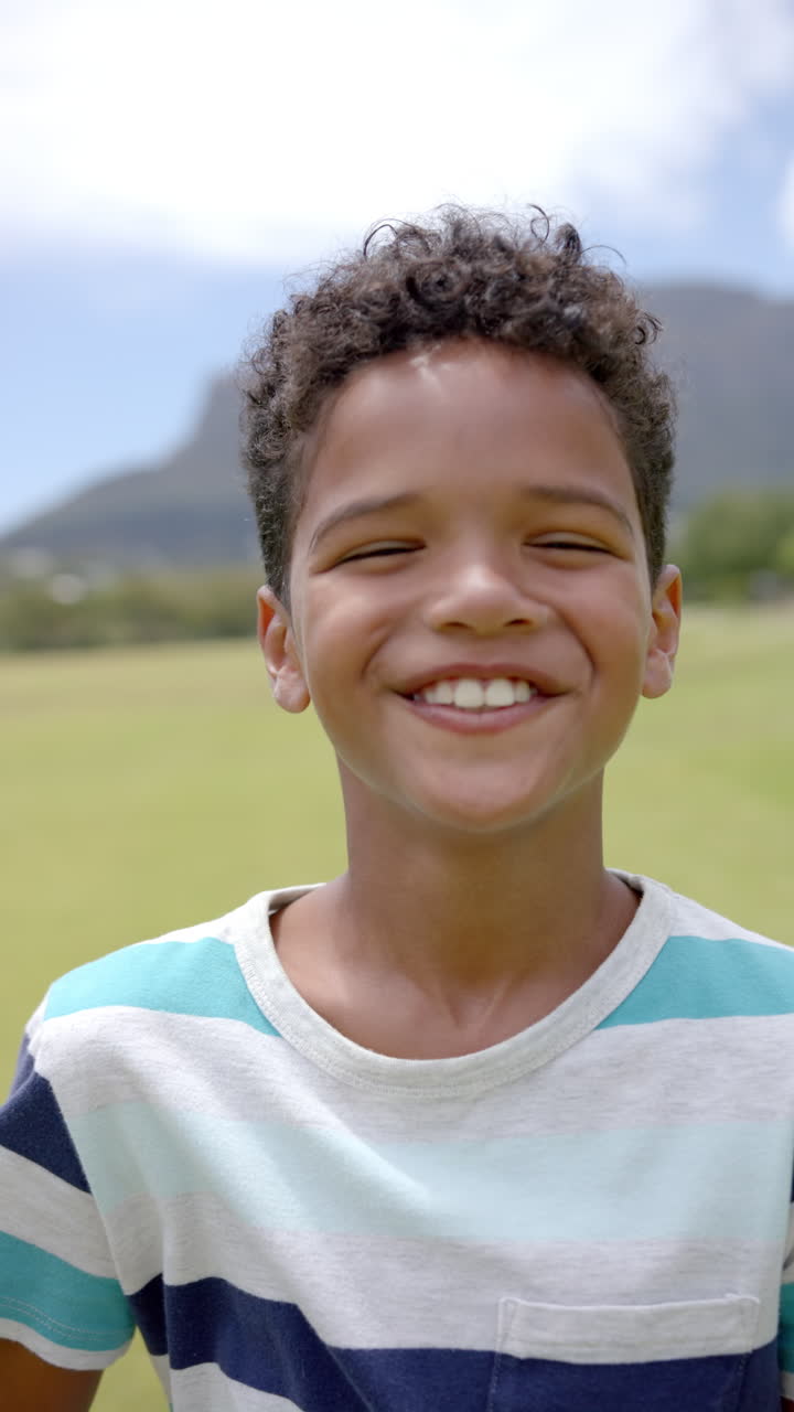 Vertical video: Enjoying sunny day, smiling child playing outdoors in school playground