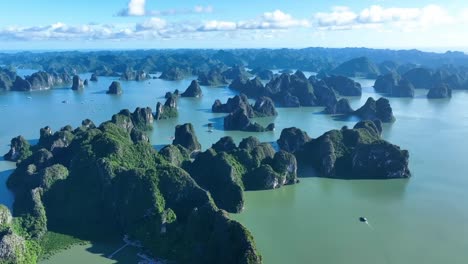 majestic limestone cliffs rise from tranquil green waters in this aerial shot of halong bay, vietnam, showcasing natural beauty, serenity, and scenic island formations.