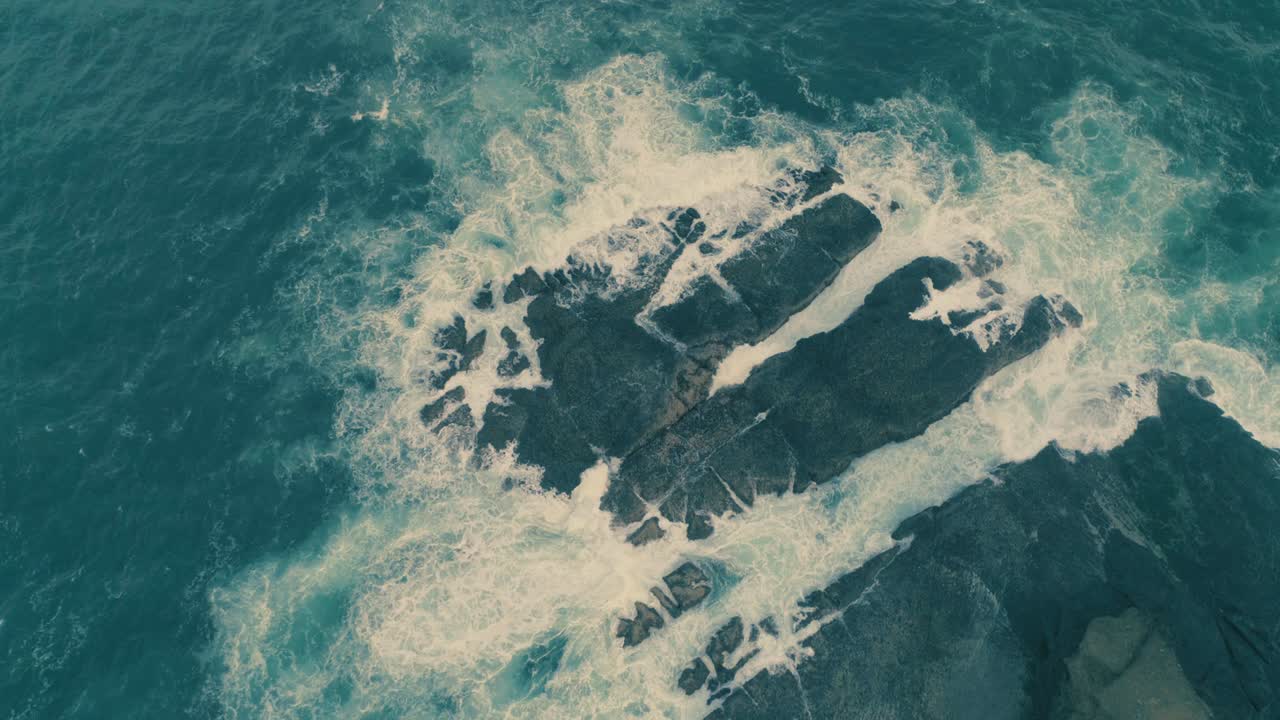 Rough sea waves hitting rocks slow motion capture an aerial view