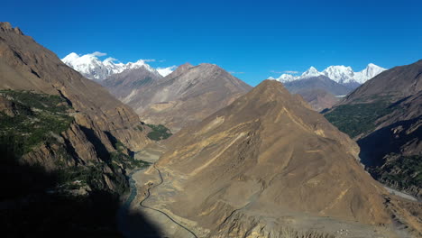 Toma-Cinematográfica-De-Drones-De-Conos-De-Passu-En-Hunza-Pakistán,-Picos-Montañosos-Cubiertos-De-Nieve-Con-Acantilados-Escarpados,-Toma-Aérea-Giratoria-Alta-Y-Ancha