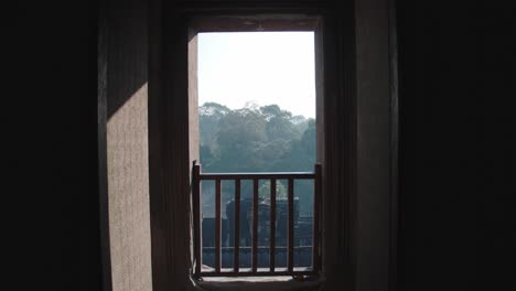 Geheimnisvoller-Blick-Auf-Angkor-Wat-Durch-Ein-Altes-Fenster-Bei-Sonnenaufgang,-Silhouettenrahmen