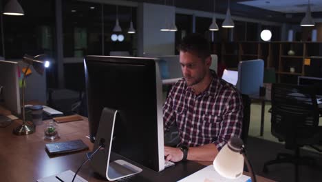 Tired-businessman-working-in-a-modern-office-by-night