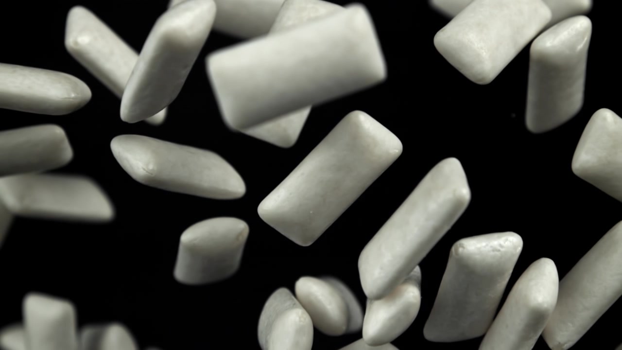 Scatto macro di pezzi di gomma da masticare bianca su sfondo nero