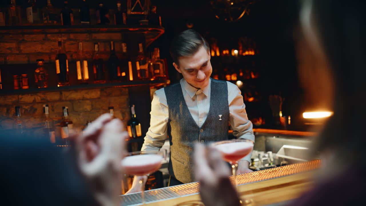 Bar gjester som setter pris på cocktails – bakfra sett. Bartender føler seg takknemlig