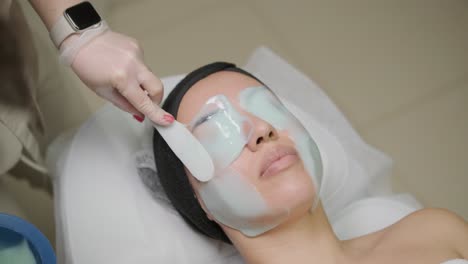 a soothing facial treatment with a thick layer of alginate mask being applied for skin rejuvenation and hydration