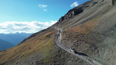 truck driving down dirt road near mountain