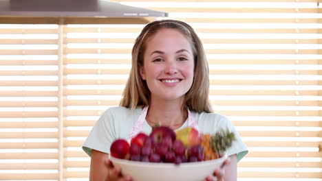 la ama de casa oliendo un plato de frutas