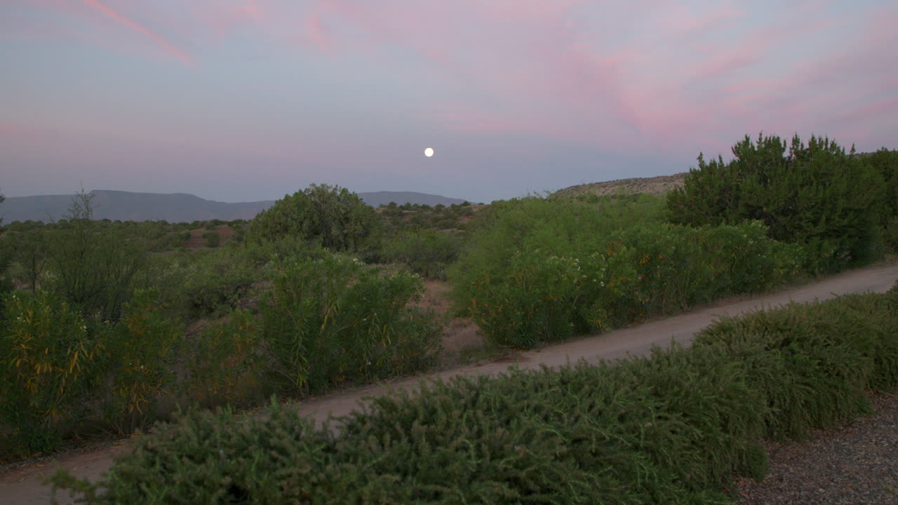 paisaje desértico al amanecer con la luna brillando