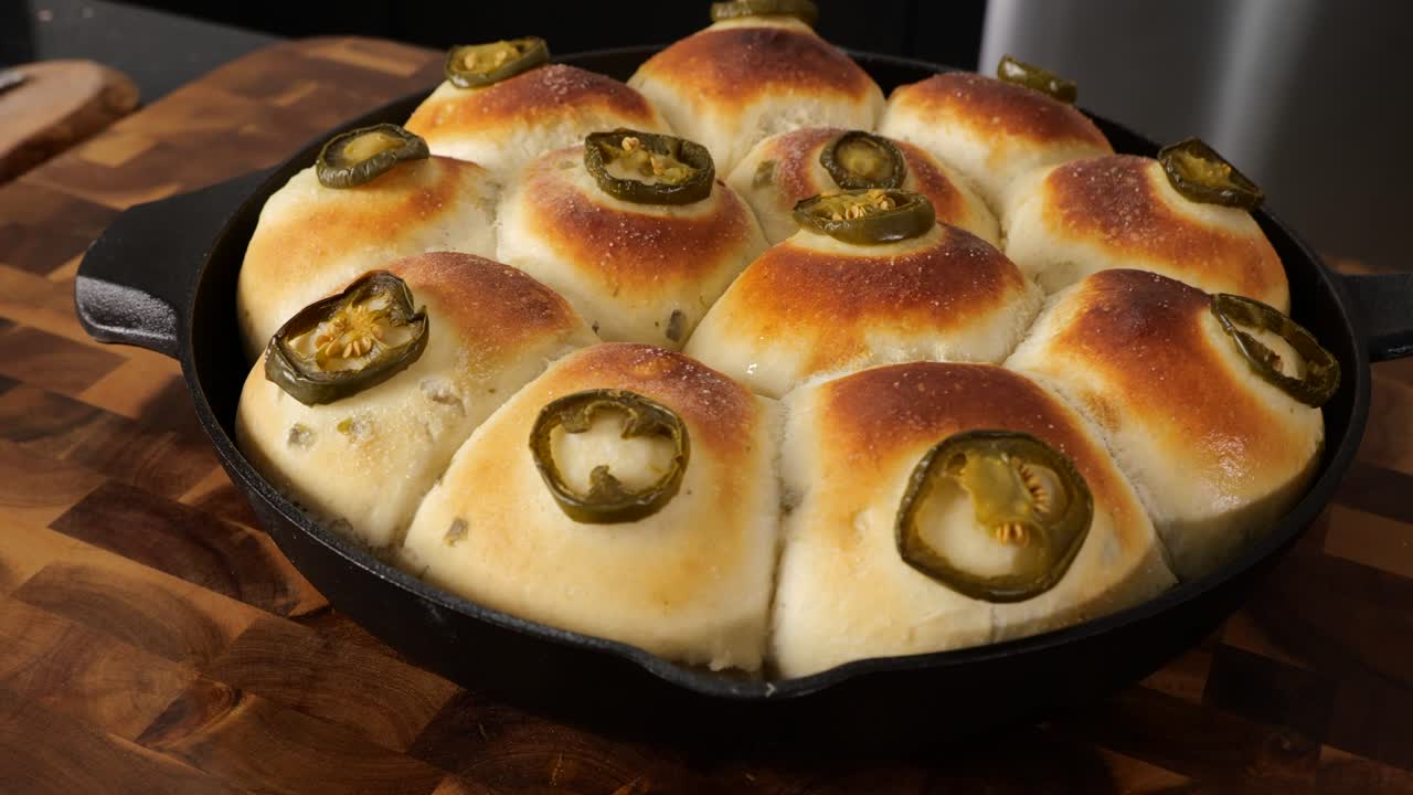 Overhead shot of fresh baked cast iron bread rolls straight out of the oven with a slow motion shot at the end