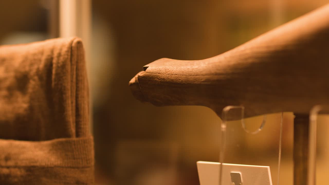 Warmly lit close-up of historical military artifacts behind glass, slow lateral camera movement, Dunkirk museum