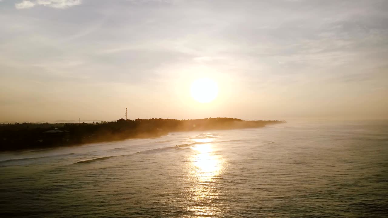 아름다운 해가 지는 바다 위를 날아다니는 드론: 해가 지고 반사되는 놀라운 공중 파노라마, 해안에 도달하는 파도