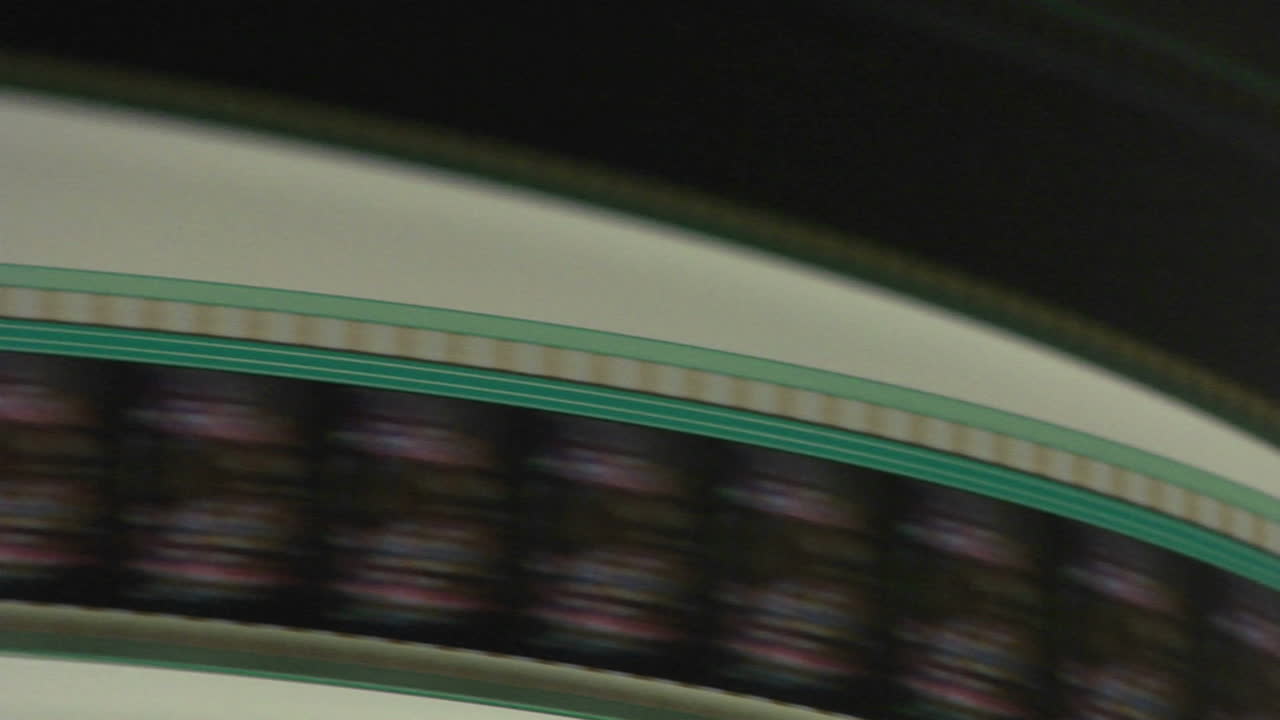 una tira de película se desliza a través de un proyector en esta toma abstracta