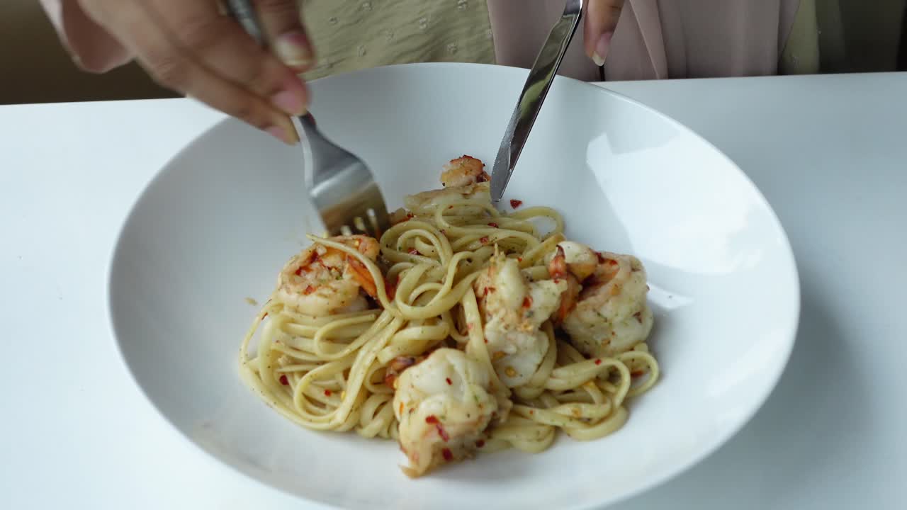 mujer comiendo pasta de camarón