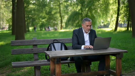 man working on laptop in park