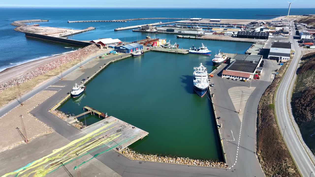 Drone footage of Hanstholm port in Denmark, showcasing fishing vessels and harbor life from a stunning aerial view.