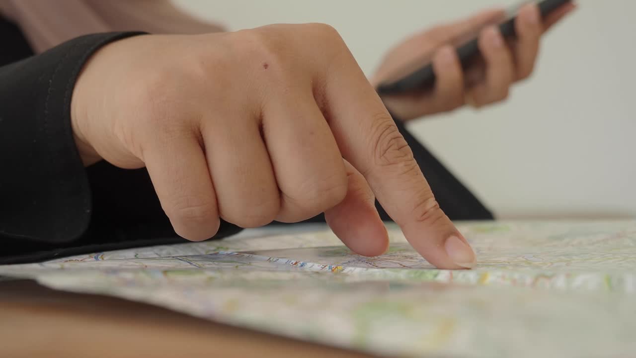 Person using a map and mobile phone