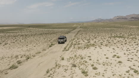 jeep driving on dirt road in arid steppe plain in vashlovani, georgia