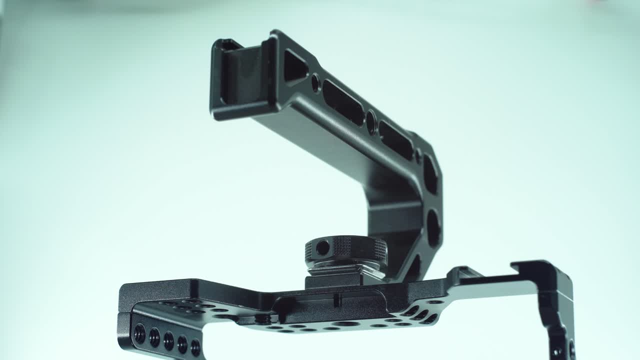 una toma cinematográfica de cerca de una jaula de cámara de metal negro con un controlador arriba, equipo de producción de video, en un soporte giratorio 360, luz de estudio, cámara lenta, 4k