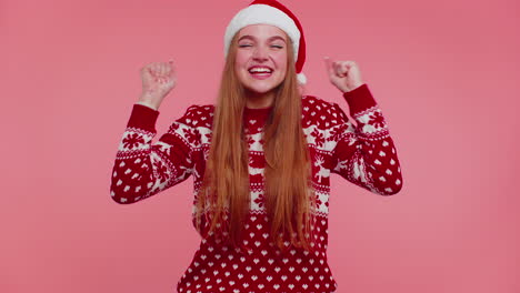una chica alegre con un suéter rojo, gritando santa claus, celebrando el éxito, la victoria, el logro de la meta.