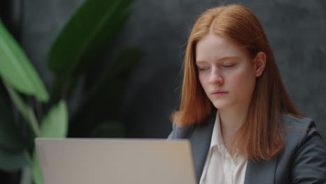 woman office worker is sitting at table with laptop and communicating in online chat