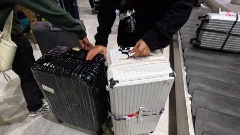 사람이 공항 컨베이어 벨트에서 짐을 가져옵니다.