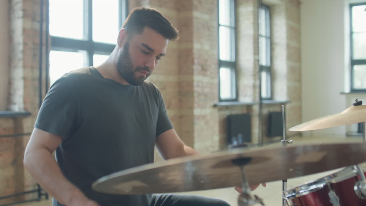 Man Drumming in Music Rehearsal Studio