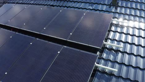 Solar-panel-installation-on-private-home---Closeup-rotating-aerial-with-details-of-panels-showing---Rotating-ascending-aerial-with-solar-flare-on-roof