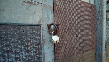 Close-up-wide-shot-of-lock-on-wooden-door-of-an-abandoned-house