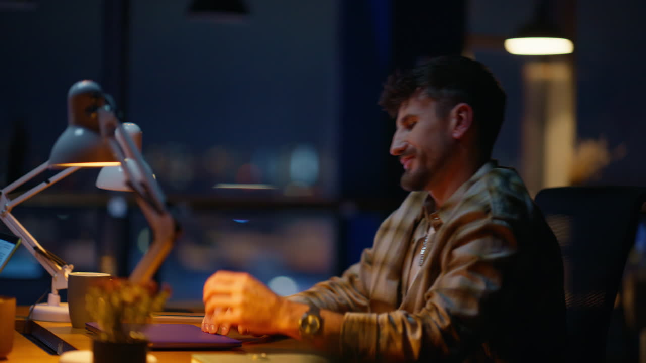 Tired man labouring evening office closeup. Night guy closing laptop ending work