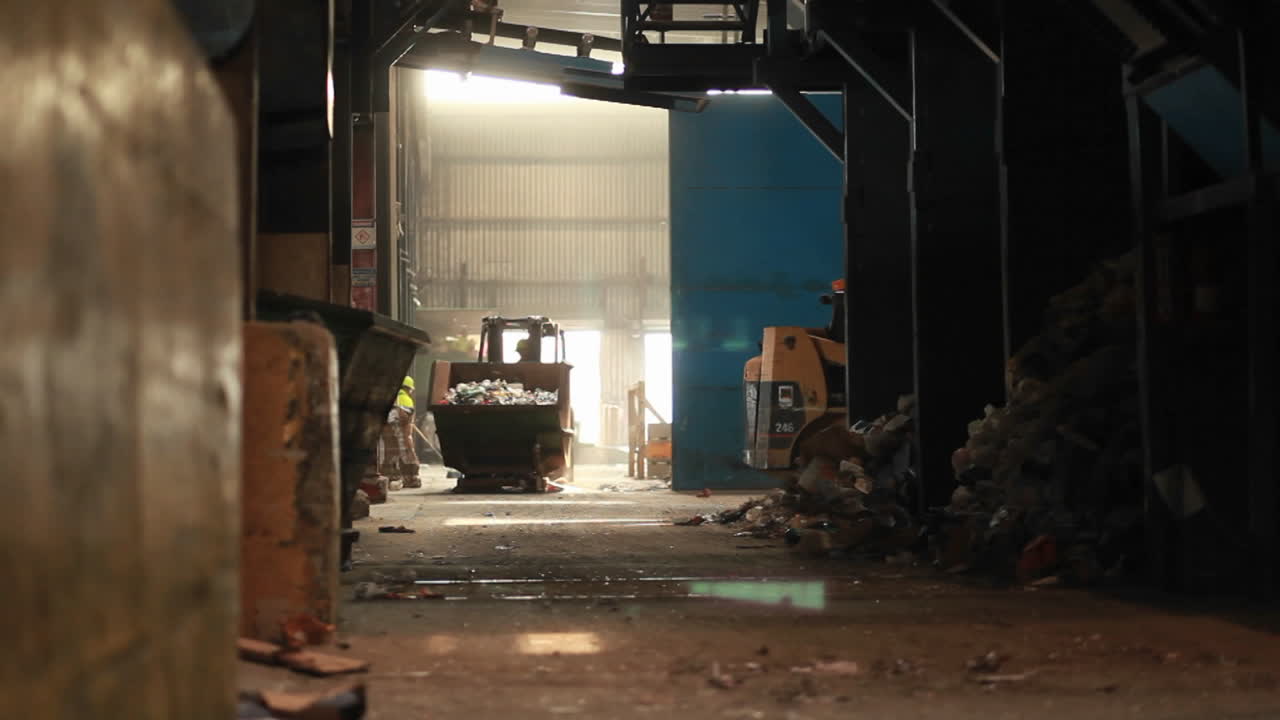 un cargador basculante recoge basura en un centro de reciclaje 1